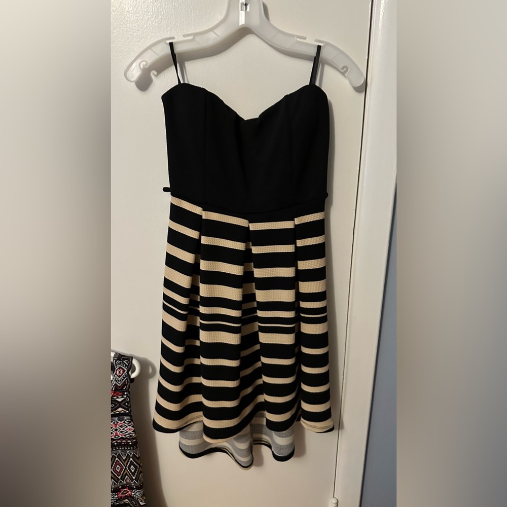 Strapless cocktail dress with black top and light brown stripes on bottom